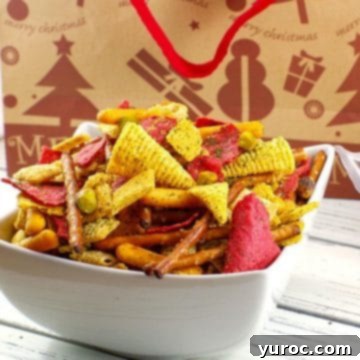 Christmas Chex Mix beautifully presented in a white bowl, with a festive Christmas gift bag subtly visible in the background.
