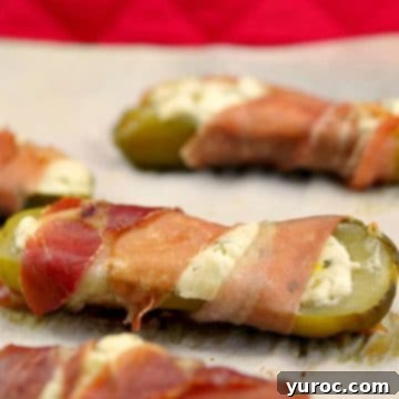 Boursin stuffed pickles neatly arranged on a parchment-lined baking sheet, ready for serving or baking.