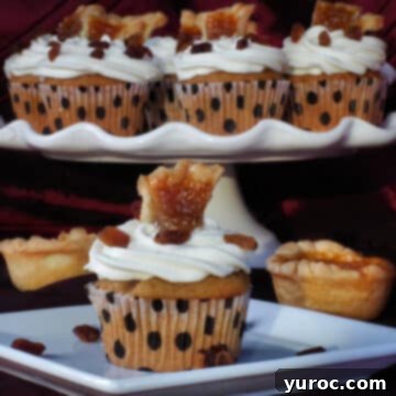 A decadent butter tart cupcake presented on a white plate, with a festive platter of more butter tart cupcakes artfully arranged in the background.