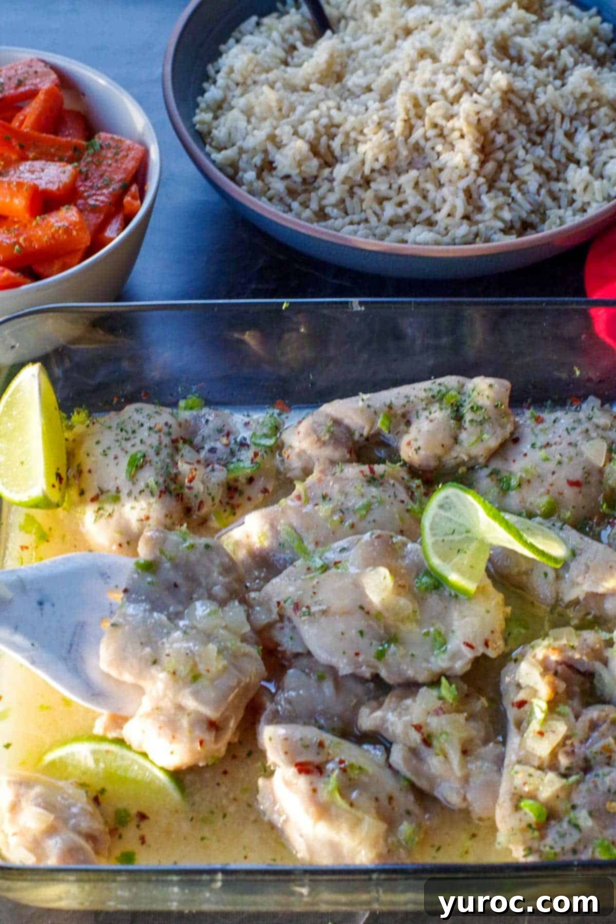 lime honey chicken in glass casserole dish with carrots and rice in the background