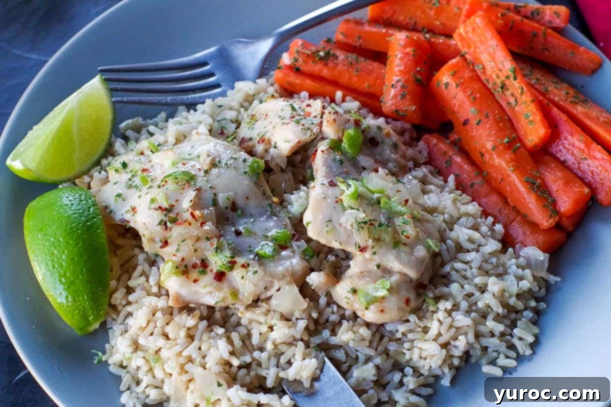honey lime chicken over rice, with carrots on the side and lime wedges, on a grey plate