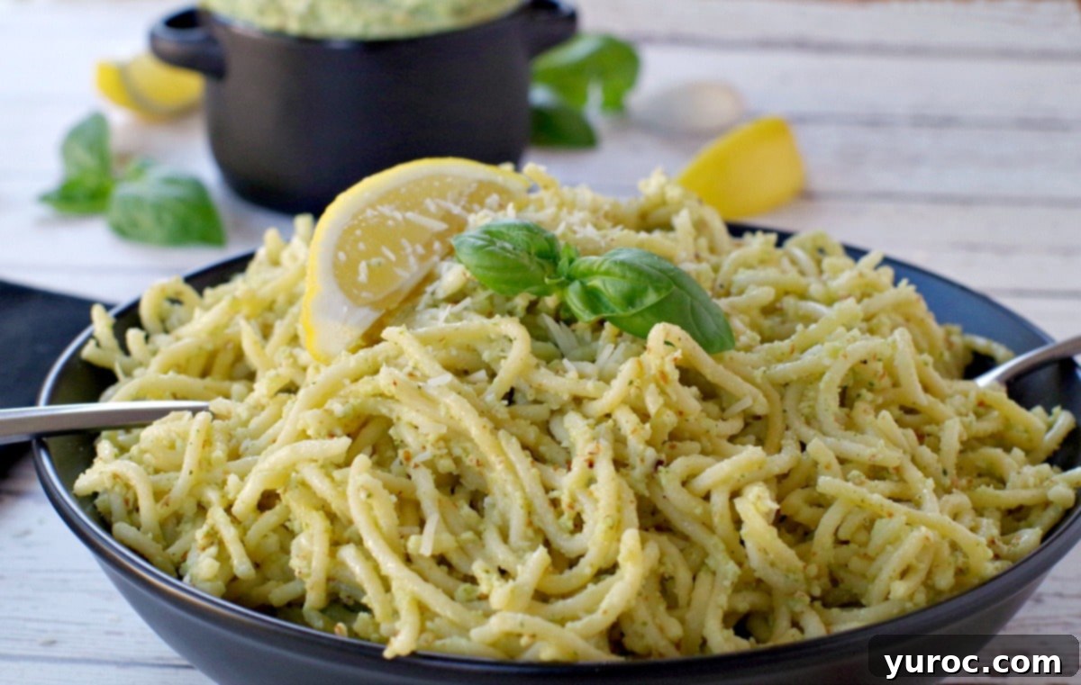 pesto on spaghetti noodles with more pesto (in black container in background)
