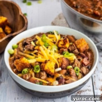 11 Legendary Chili Recipes 11 Tri tip steak chili in a white bowl with pot of chili in the background
