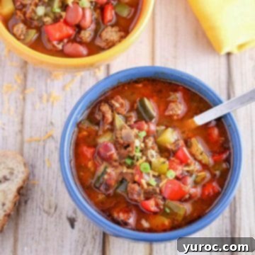 11 Legendary Chili Recipes 12 Indian Spiced Turkey Chili in a blue bowl with spoon and yellow bowl of chili in the background