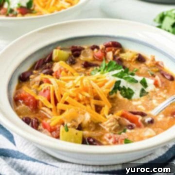 11 Legendary Chili Recipes 3 ground turkey chili in a white bowl with blue and white linen in front and another bowl of chili in the back