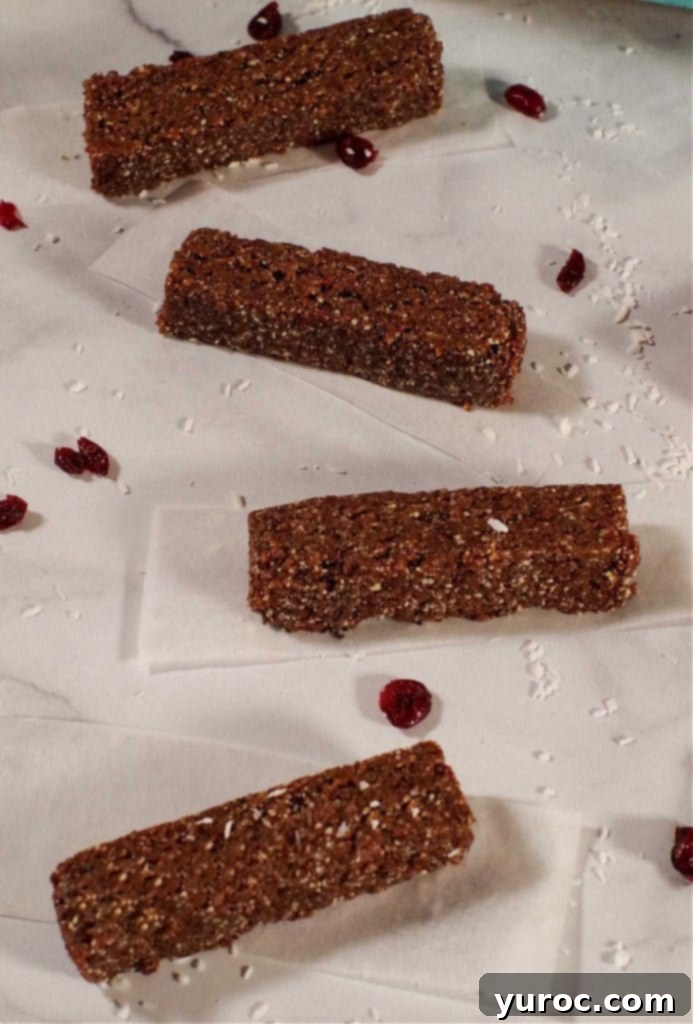 4 no bake homemade energy bars on pieces of parchment paper, spread out on a counter top