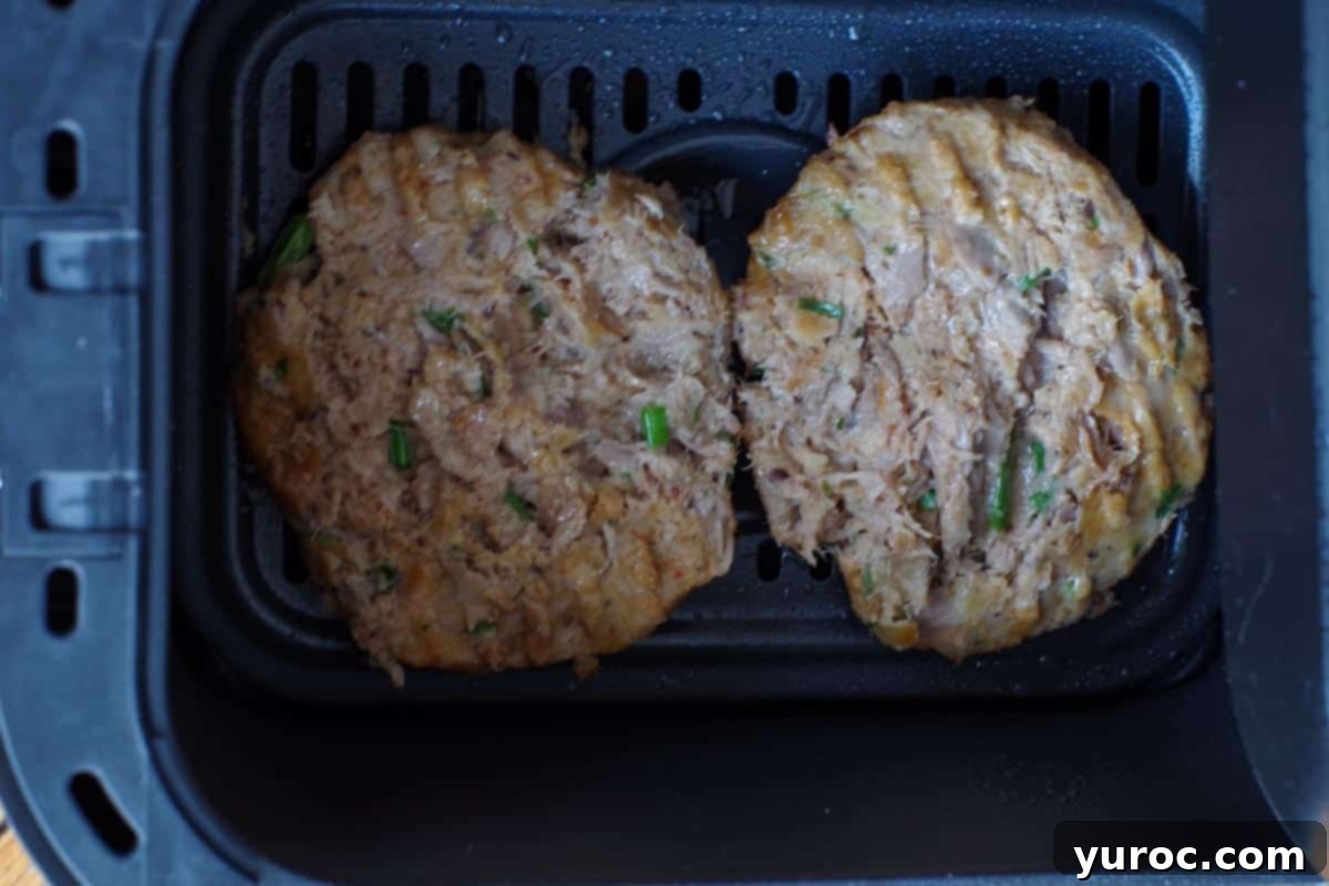 tuna burgers flipped over in air fryer.