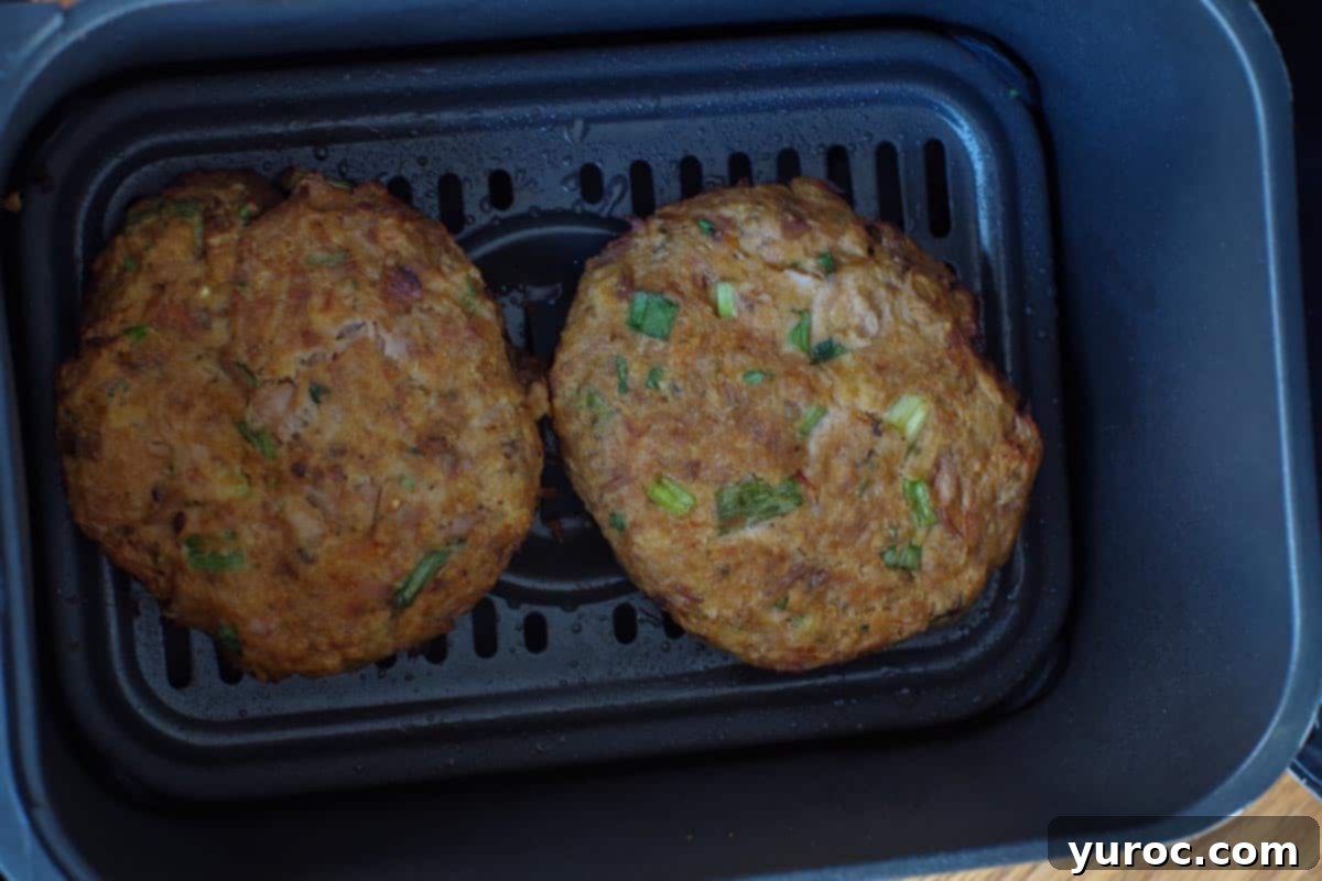 cooked tuna burgers in air fryer basket or drawer