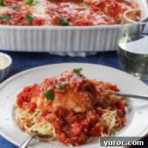 Rustic Baked Chicken Cacciatore 9 Chicken cacciatore served on noodles, on a white plate with a glass of wine and a casserole dish of more chicken cacciatore in background.