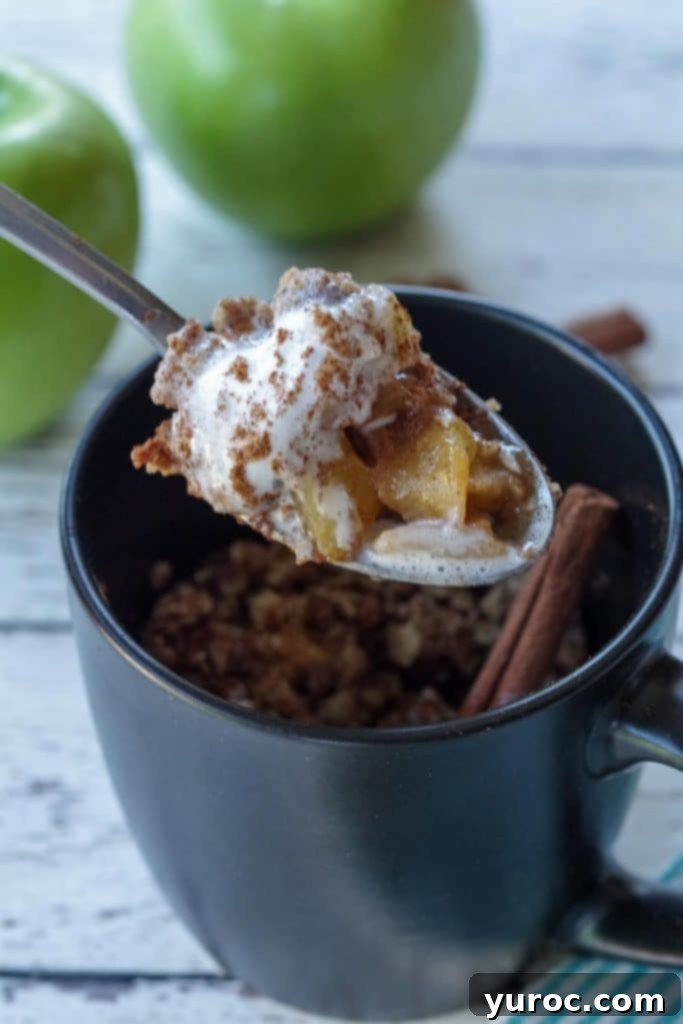 45 Effortless Tips for Boosting Your Produce Intake 22 spoon with apple crisp being held up above a black mug apple crisp with 2 green apples and cinnamon sticks in the background