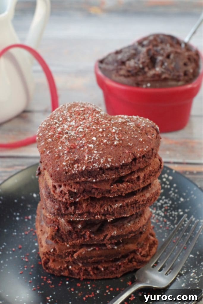 45 Effortless Tips for Boosting Your Produce Intake 5 stack of 6 healthy red velvet pancakes on a black plate with a fork on the side, heart-shaped dish with chocolate cream cheese butter, in the background