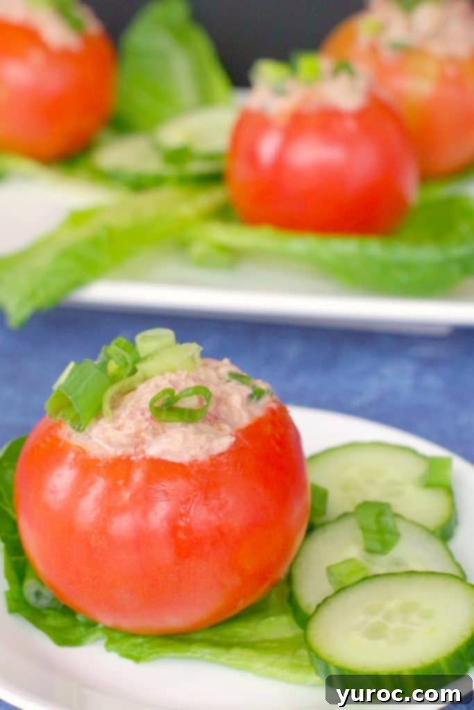 45 Effortless Tips for Boosting Your Produce Intake 7 Tuna stuffed tomato on white plate with 3 more tomatoes on platter in background