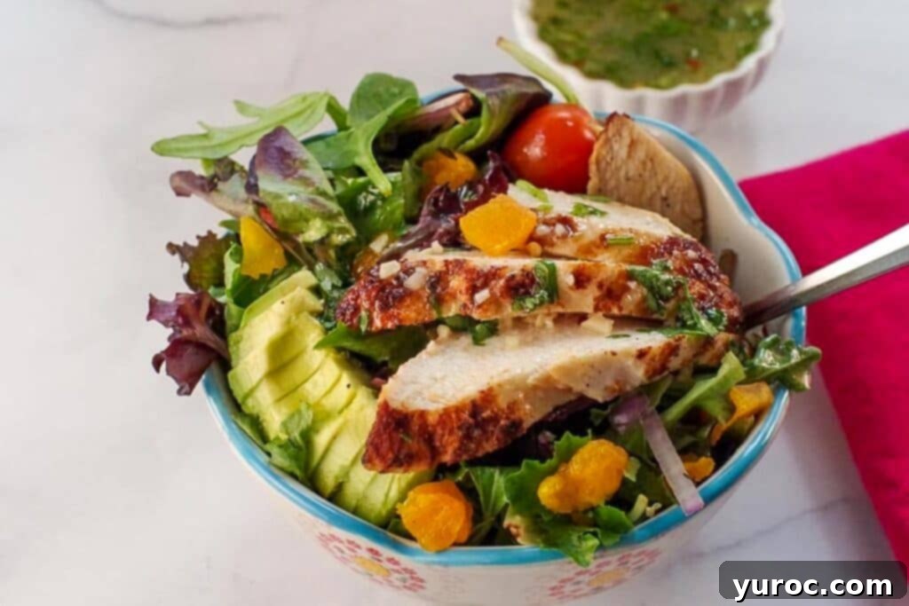 Fiery Cajun Mango Chicken Salad 2 Cajun Chicken Mango Salad in a bowl with honey cilantro dressing in a small white container and a red napkin on the side