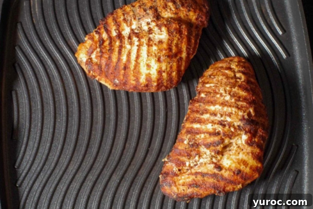 Fiery Cajun Mango Chicken Salad 4 Chicken being grilled on stovetop grill.