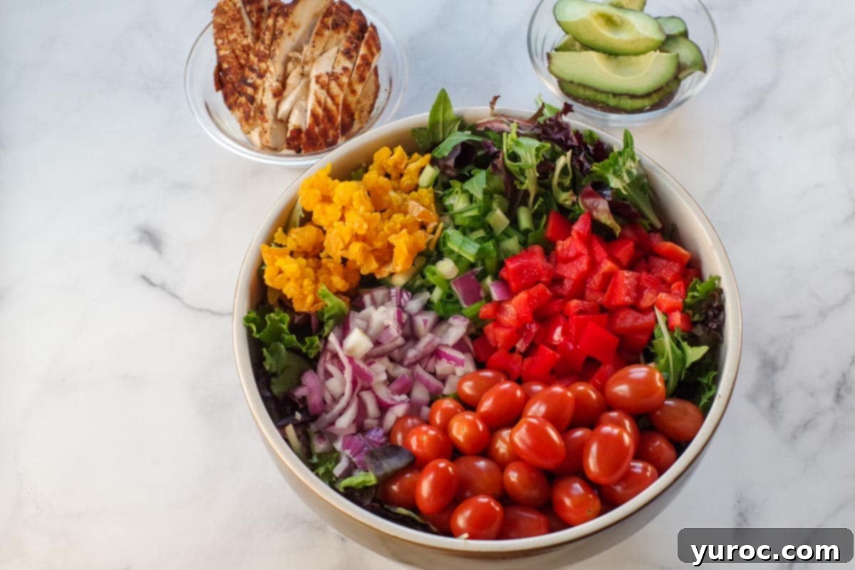 Fiery Cajun Mango Chicken Salad 5 Ingredients for chicken, avocado mango salad in a large yellow bowl, with small glass bowls of grilled chicken and avocado