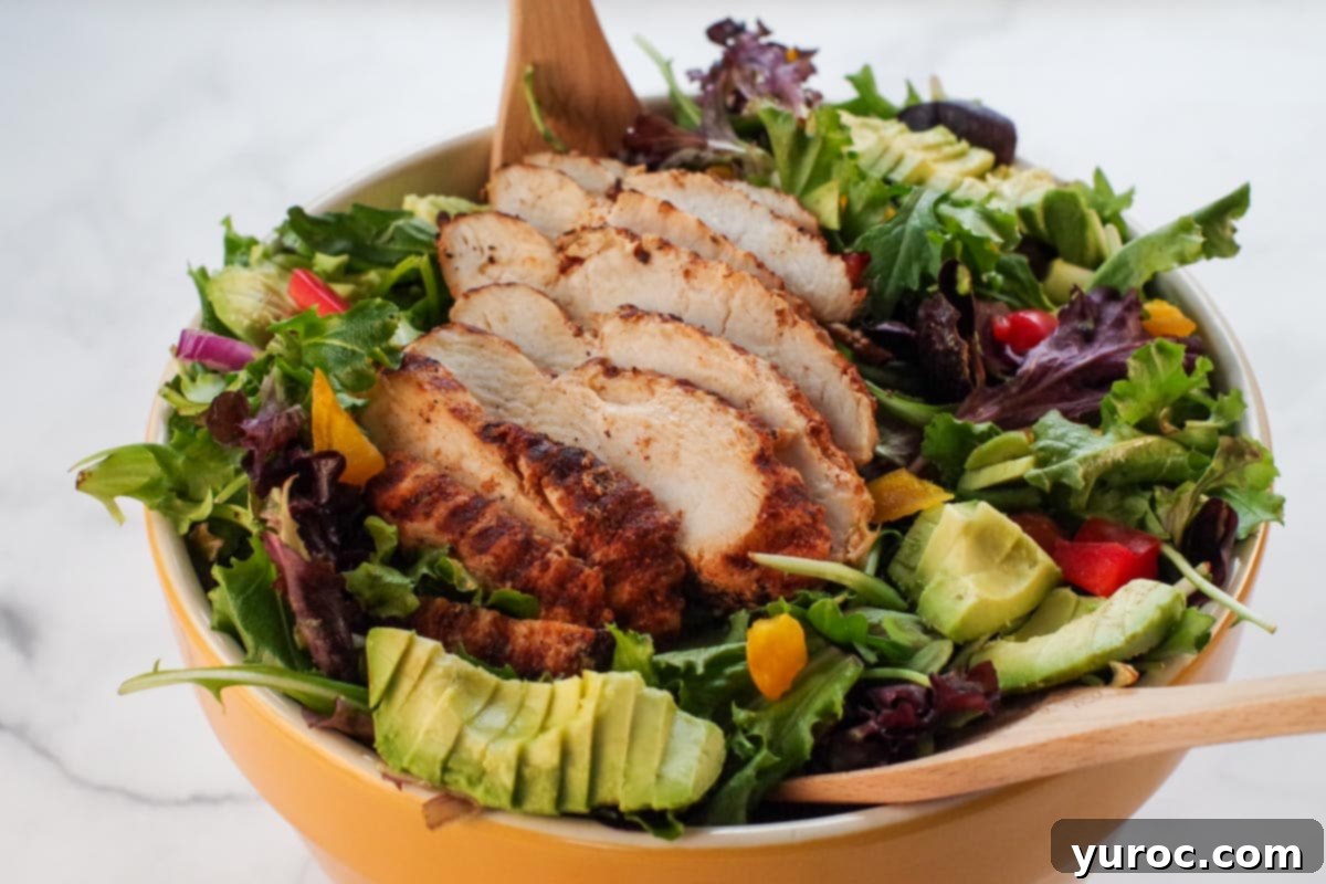 Fiery Cajun Mango Chicken Salad 6 Cajun chicken avocado and mango salad in a large yellow bowl with serving untensils