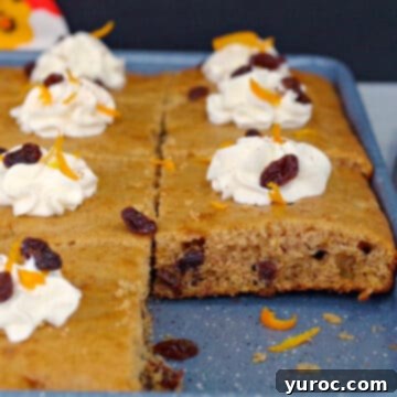 Golden-brown sheet pan raisin and rum pancakes cooling on a vibrant blue baking sheet, ready to be sliced and served.