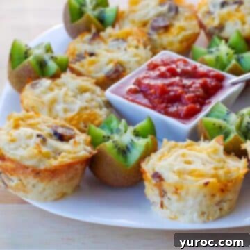 Delicious brunch bites arranged on a white plate, beautifully garnished with kiwi flowers and a vibrant dish of salsa in the center for dipping.