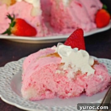A delightful piece of strawberry jello angel food cake served on a white plate, with the entire cake visible in the background, showcasing its light and airy layers.