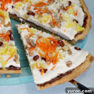 A delicious slice of carrot cake dessert pizza being carefully removed from the whole pizza, showcasing its tempting layers and colorful toppings.