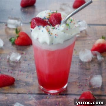 A refreshing Strawberry Italian Soda served in a tall glass, garnished with fresh strawberries, colorful sprinkles, and ice surrounding it.