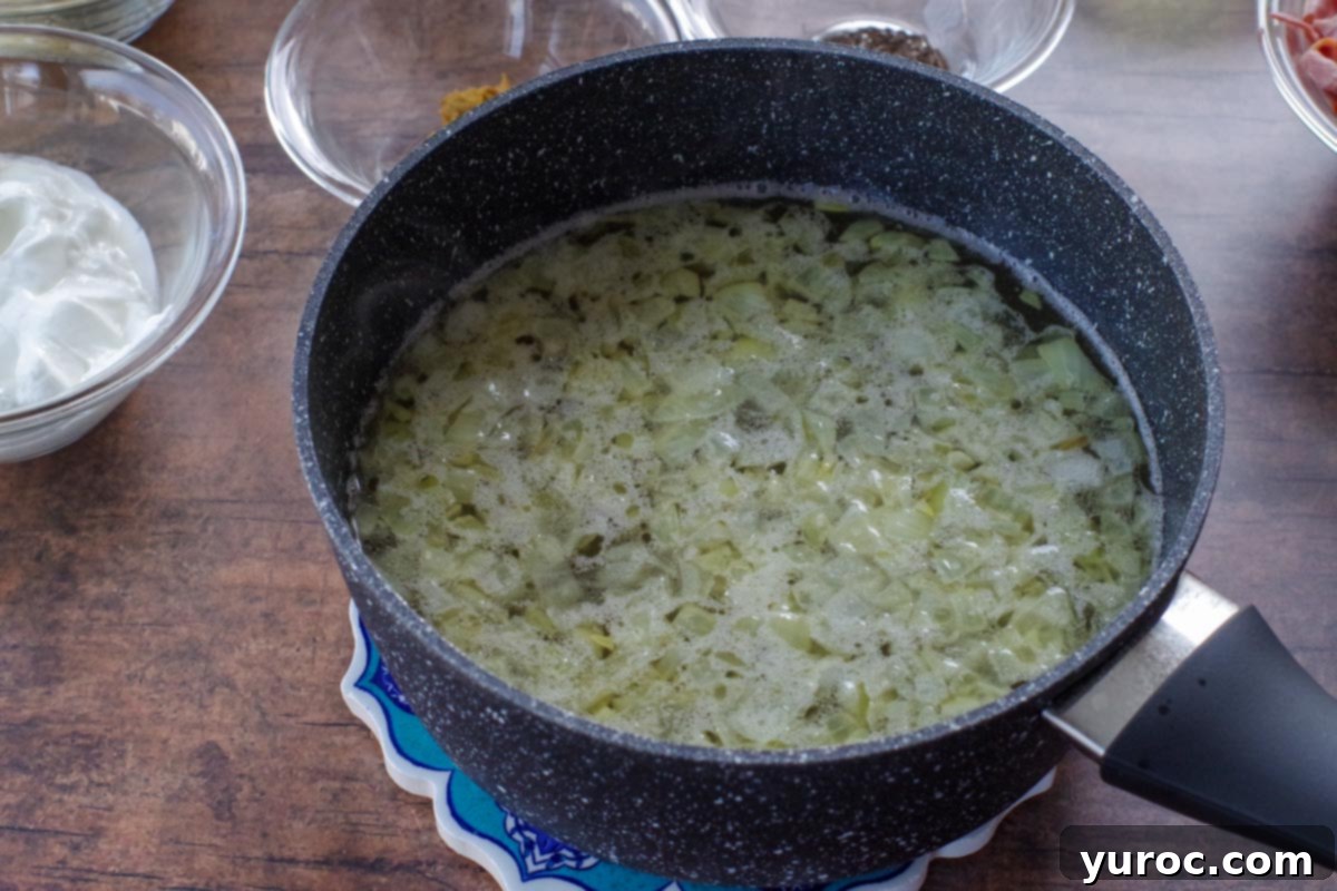 beef stock added to onion butter mixture in a pot