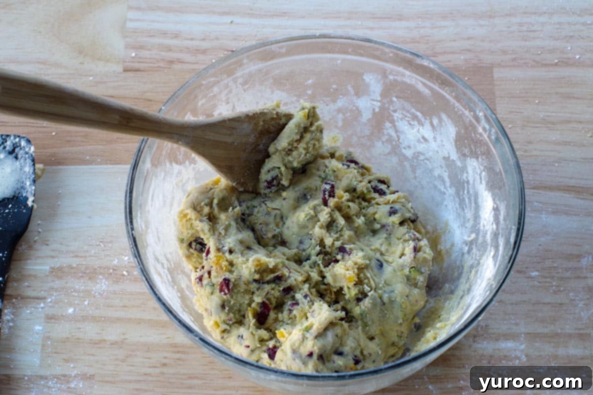 Dough in a glass bowl with a wooden spoon, showing the final mixed dough before chilling.