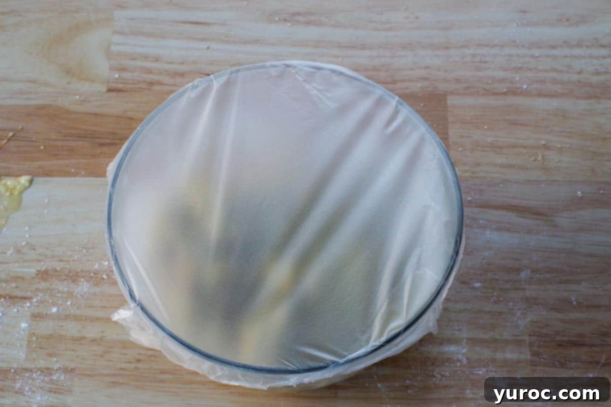 Bowl covered with saran wrap (press n' seal), indicating the dough chilling process.