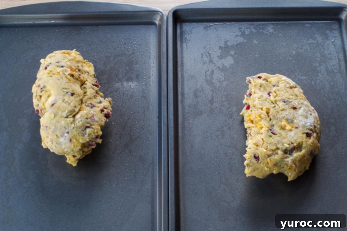 Dough divided in 2 on two greased baking sheets, prepped for shaping and baking.