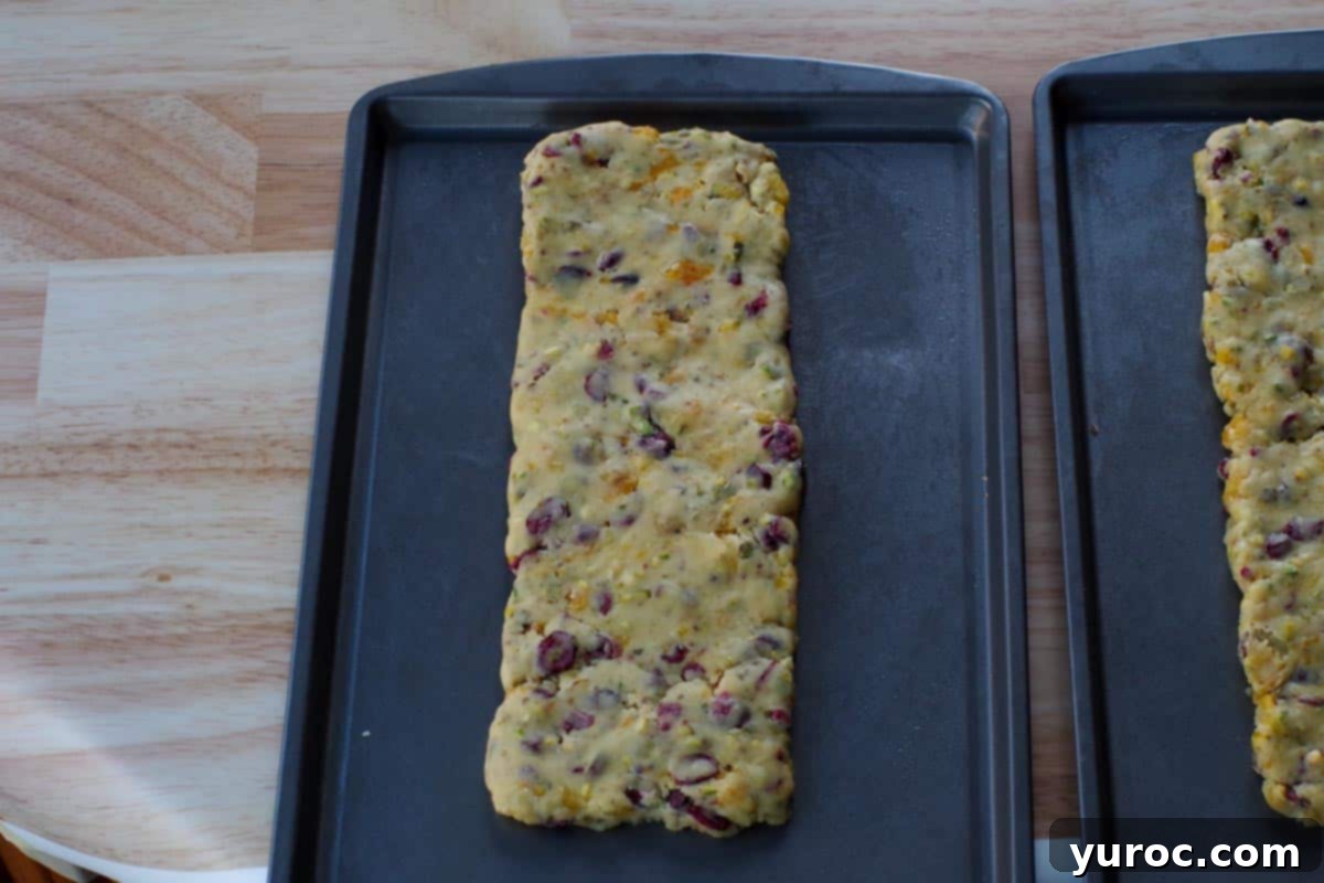 Dough shaped into a log on a baking sheet, ready for the first bake.