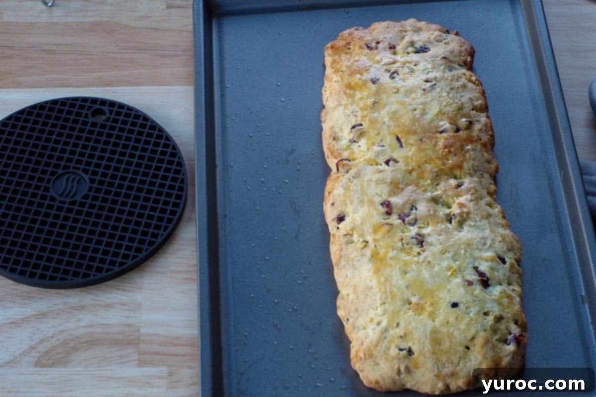 Baked loaf on a cookie sheet, golden brown and perfectly risen after the first bake.