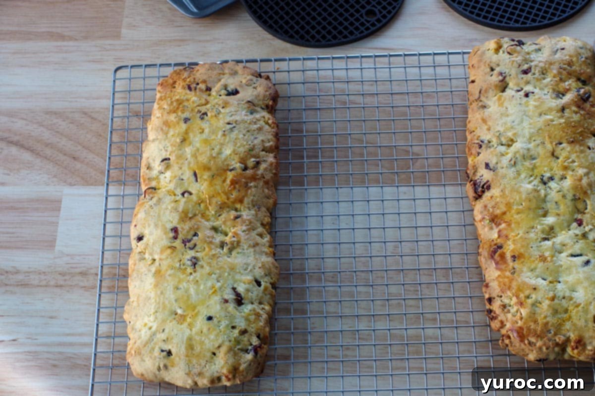 Biscotti loaves moved to a cooling rack, continuing the cooling process for an extended period.