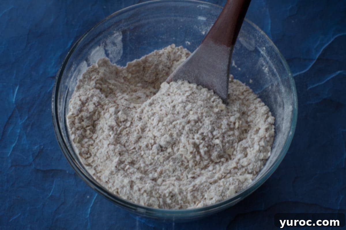flour mixture in glass bowl with wooden spoon