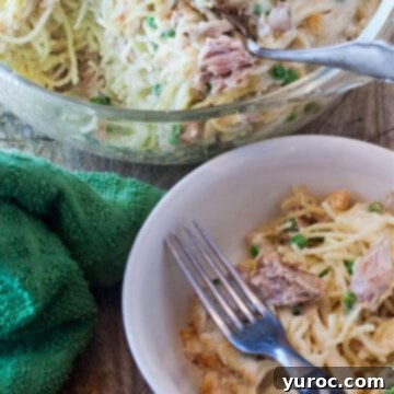 Spaghetti Casserole in a white dish with a fork and a casserole dish of more in the background