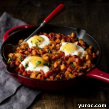sweet potato hash with eggs on top in black cast iron pan