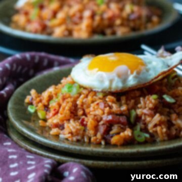 Gochujang fried rice in a bowl with egg on top and more rice in background