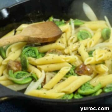15 Creative Fiddlehead Dishes 12 fiddlehead sausage penne in a cast iron frying pan, with a wooden spoon stirring it