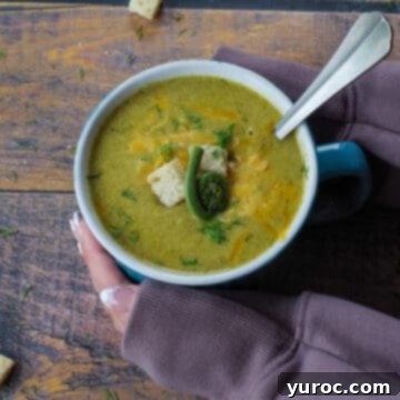 15 Creative Fiddlehead Dishes 5 fiddlehead soup in a mug with a spoon in it and hands cradling it