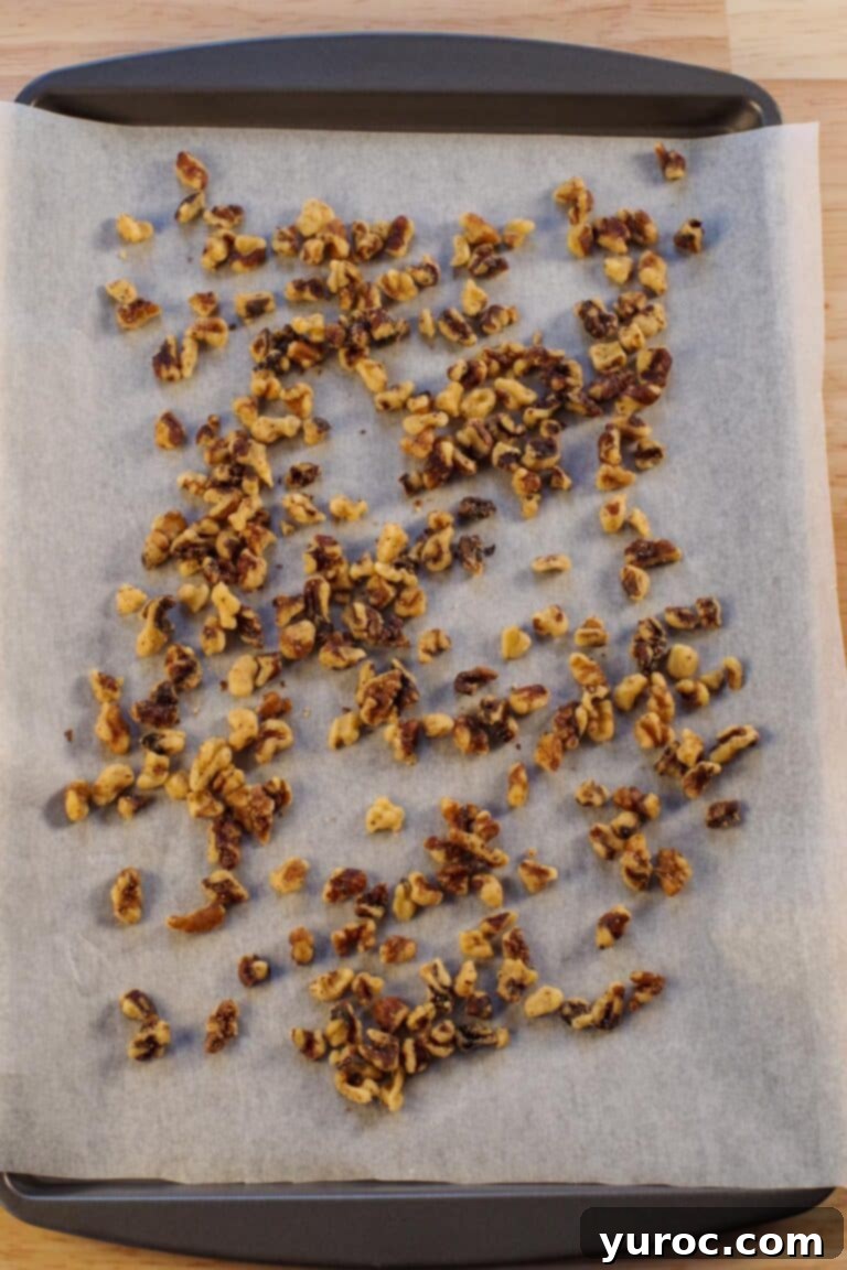 Walnuts toasted on a parchment covered baking sheet.