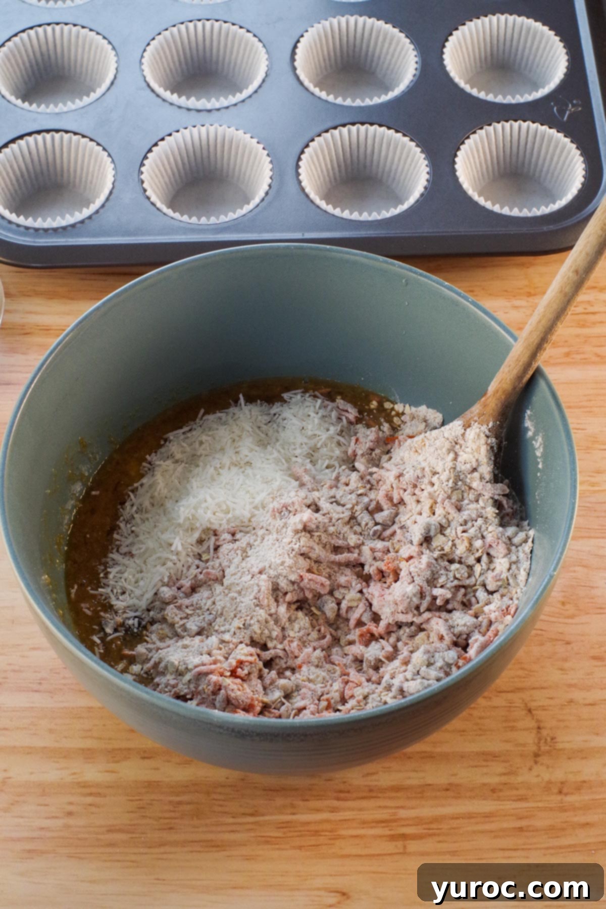 blue bowl with dry ingredients and coconut added and wooden spoon