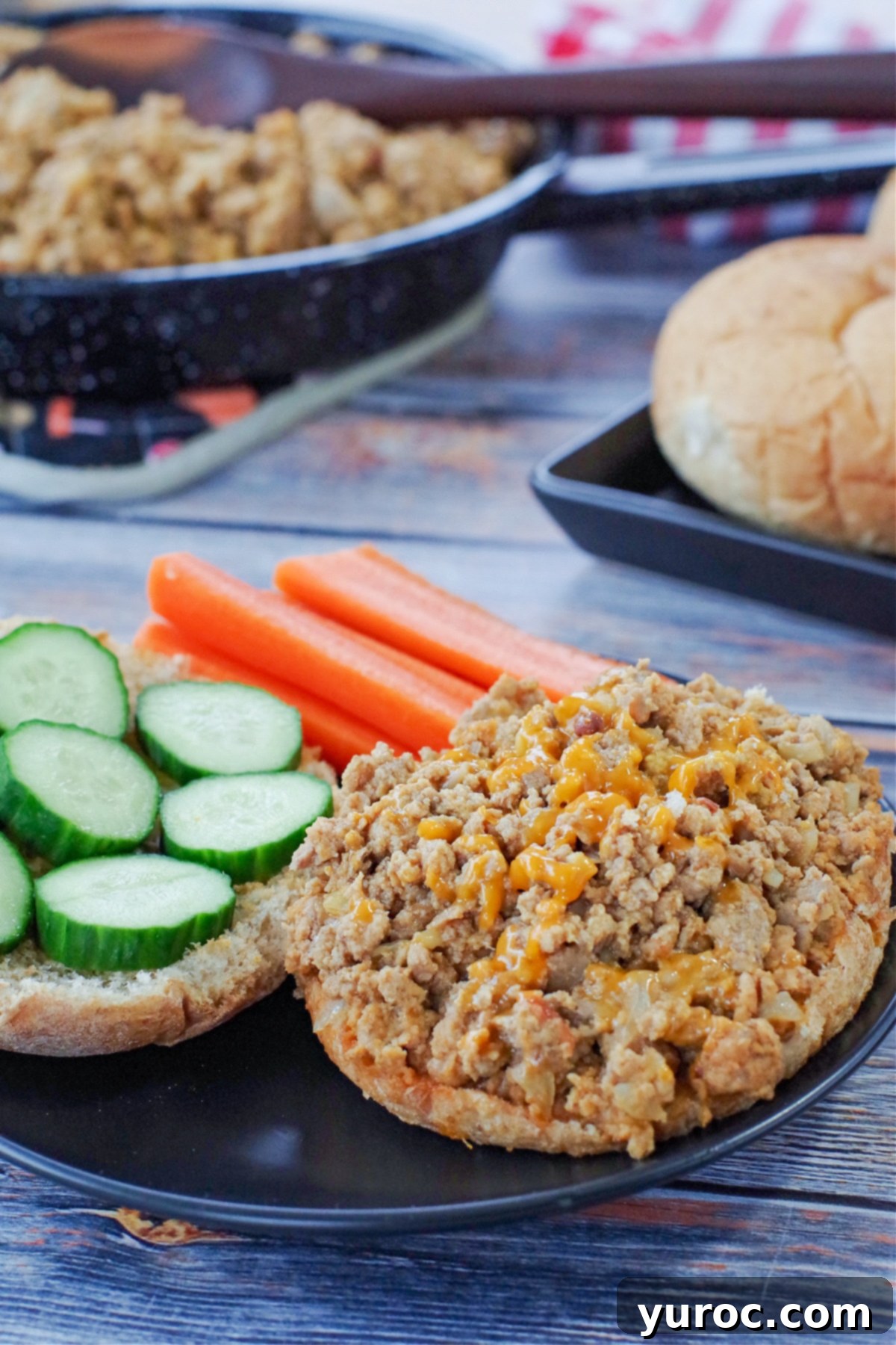 Guilt-Free Turkey Sloppy Joes 4 weight watchers turkey sloppy joes on a black plate with veggies and a skillet of more in the background