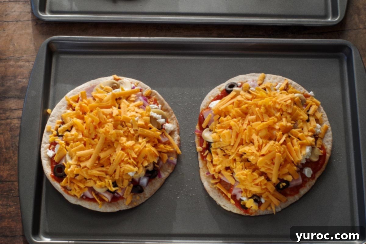 Pita pizzas baking on a sheet pan in the oven, illustrating step 5.