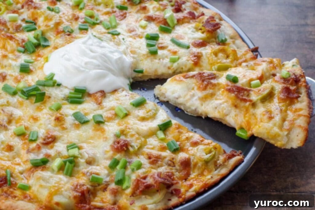 A tantalizing slice of Perogy Pizza being gracefully lifted from the pan, revealing its crispy crust and perfectly melted, bubbly toppings.