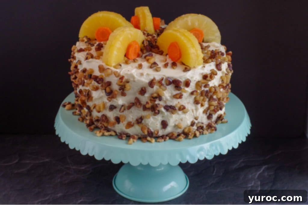 Guilt-Free Carrot Cake Delight 2 whole carrot cake decorated with pineapple and carrots on a aqua cake stand