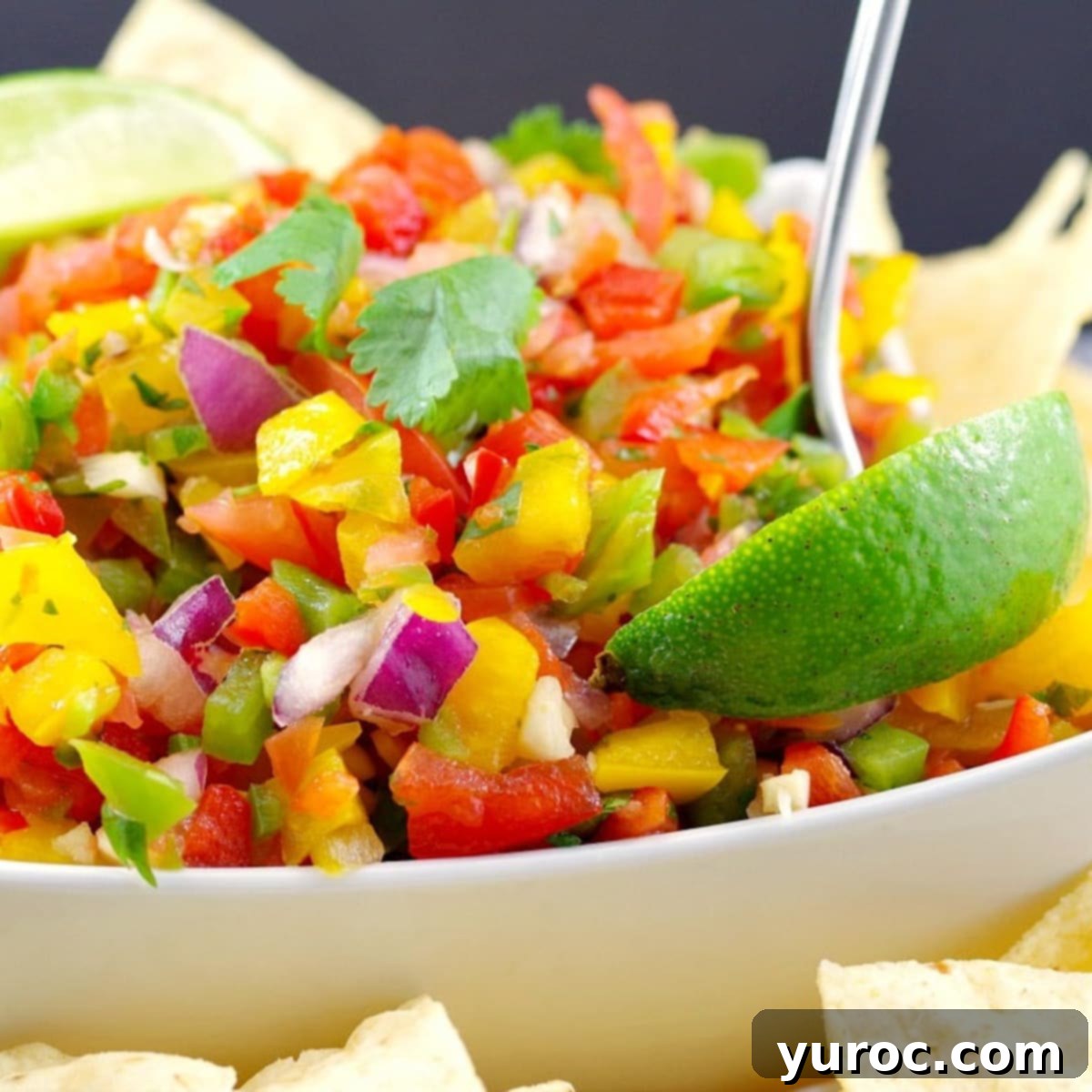 Mediterranean Slim Crustless Quiche 12 Pico de Gallo Salsa in a white bowl with a spoon, wedge of lime and tortilla chips on the side