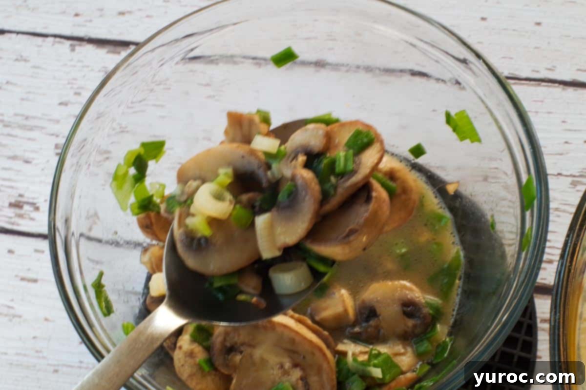 Mediterranean Slim Crustless Quiche 6 slotted spoon with mushroom and onion being strained