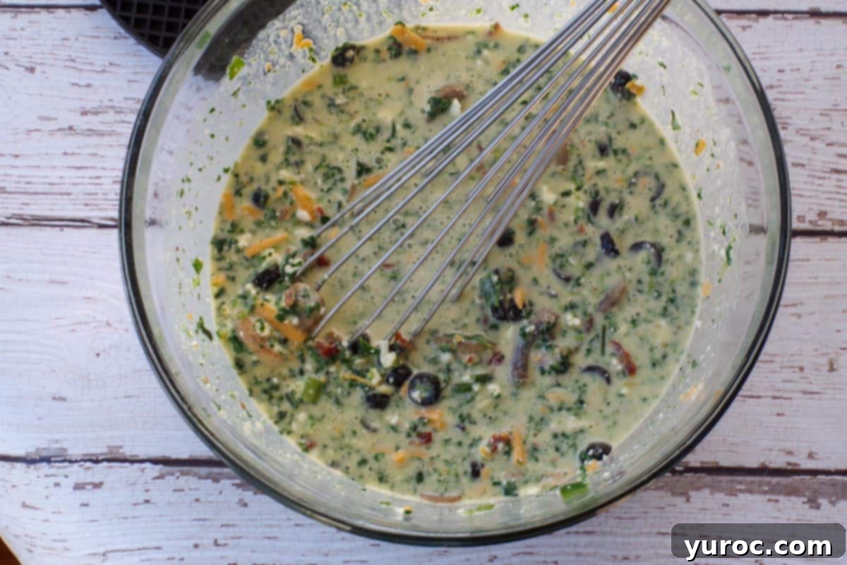 Mediterranean Slim Crustless Quiche 8 all ingredients being whisked together with whisk