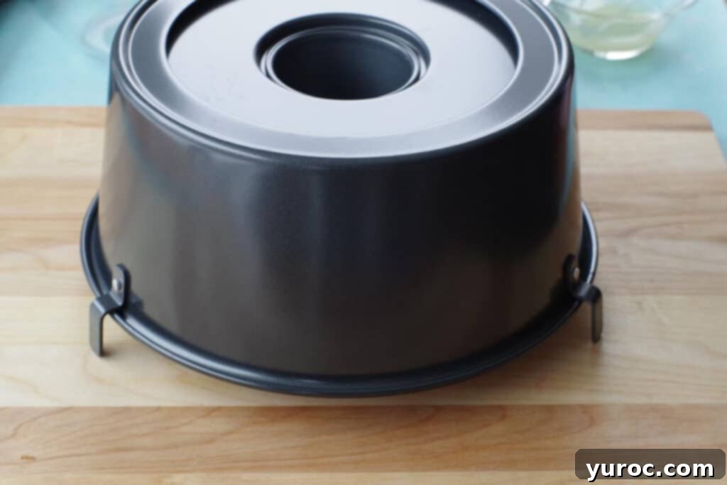 angel food cake pan with feet, inverted on a wooden cutting board