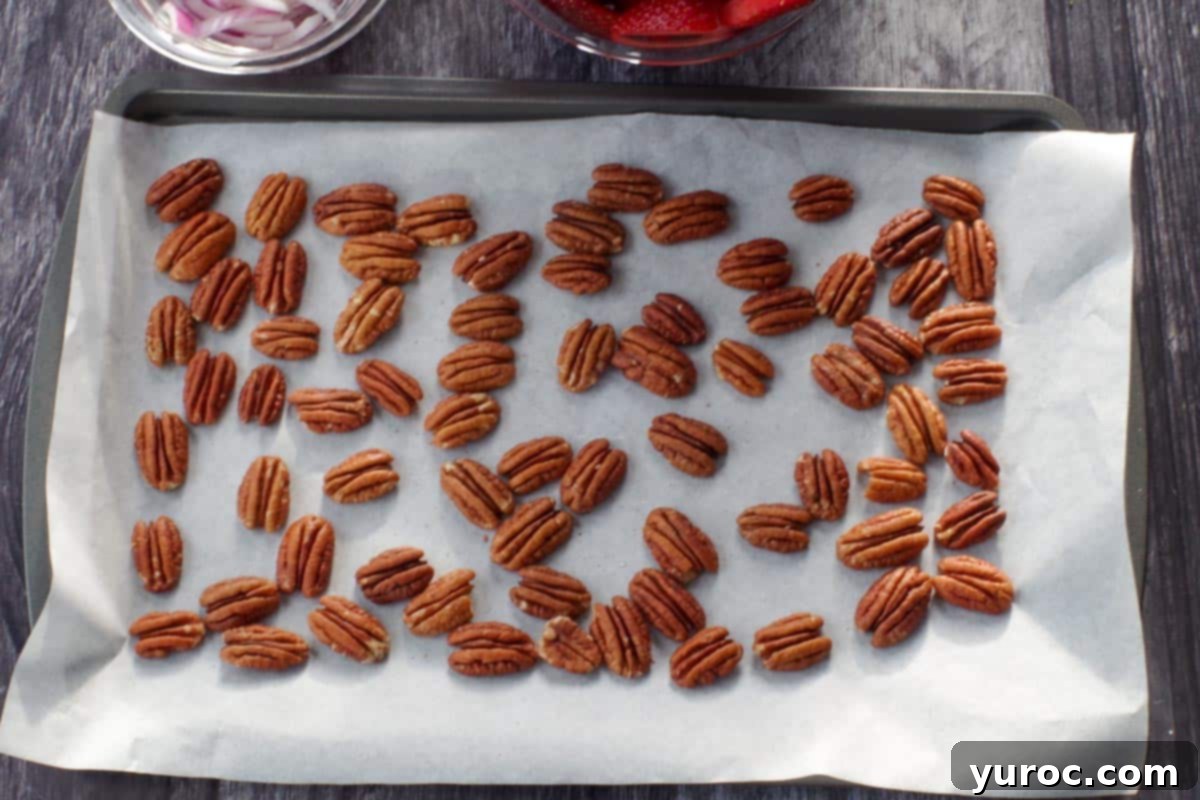 pecans on a parchment lined baking sheet