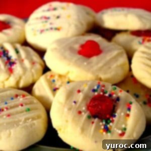 4 ingredient whipped shortbread piled on a plate with red background